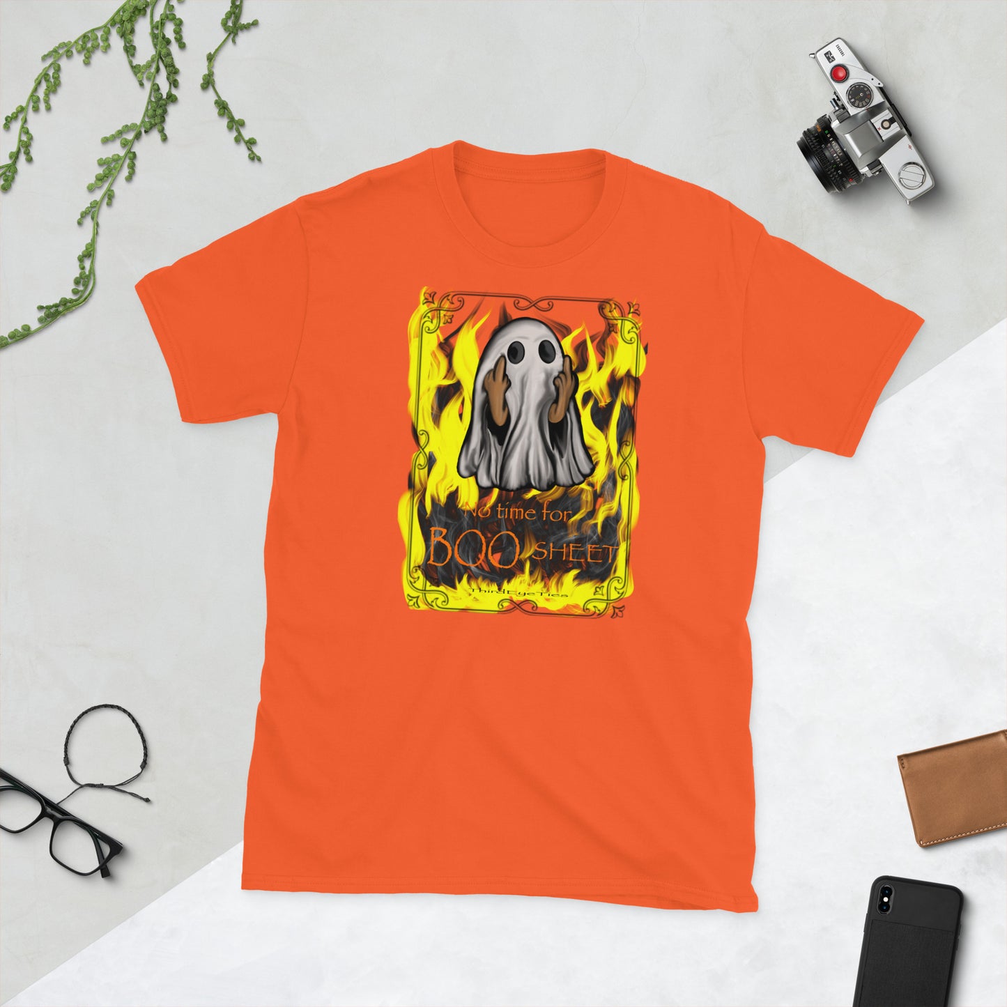 Orange t-shirt with a graphic design featuring a ghost and flames on a light gray background.